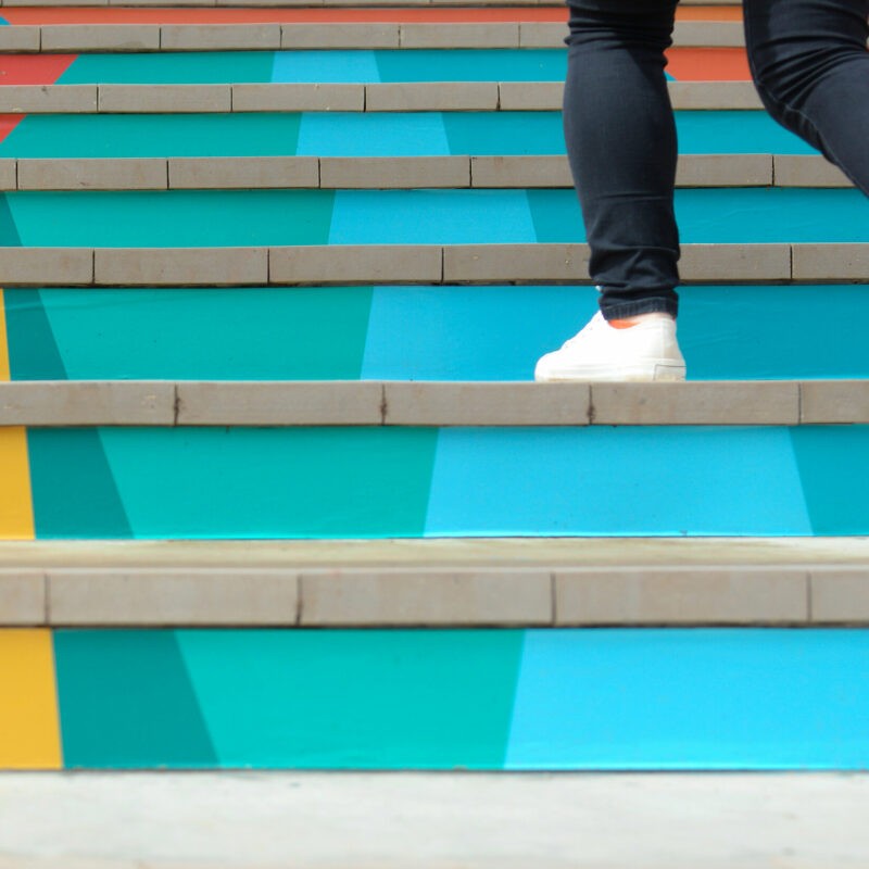 homme jean monte escalier coloré