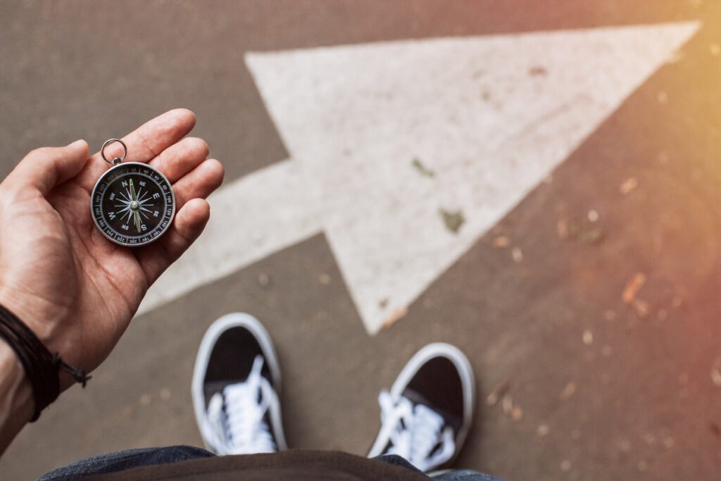 homme en basket boussole main