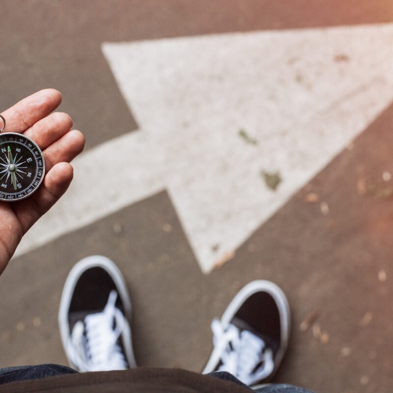 homme en basket boussole main
