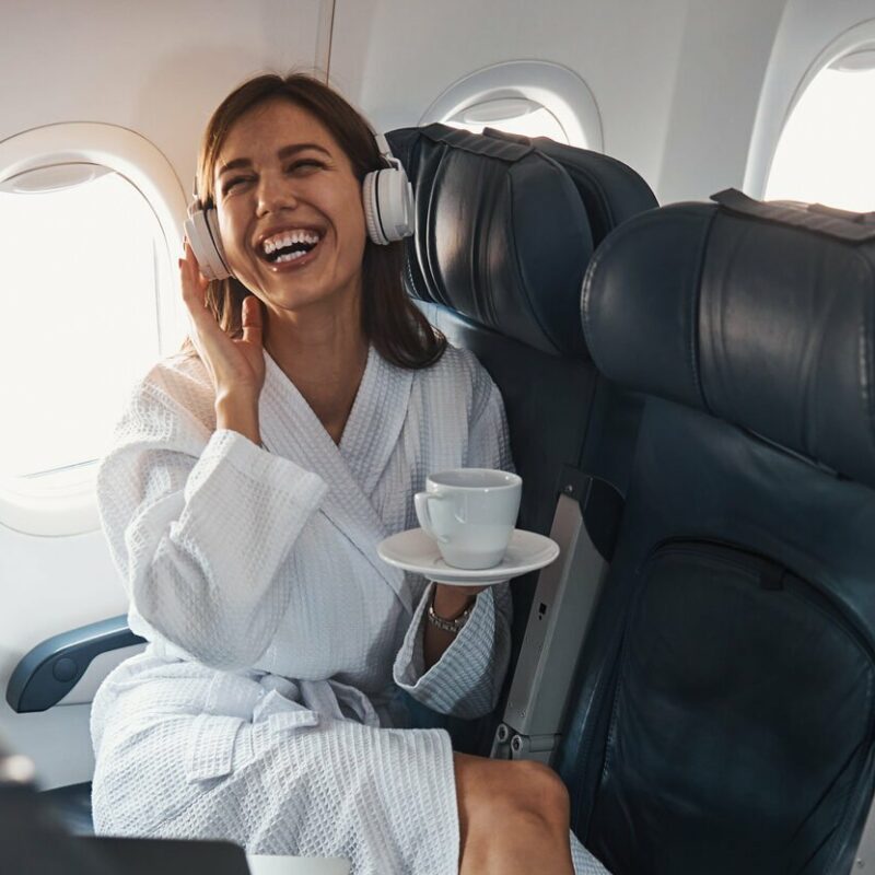 femme assise avion rire tasse peignoir expérience client