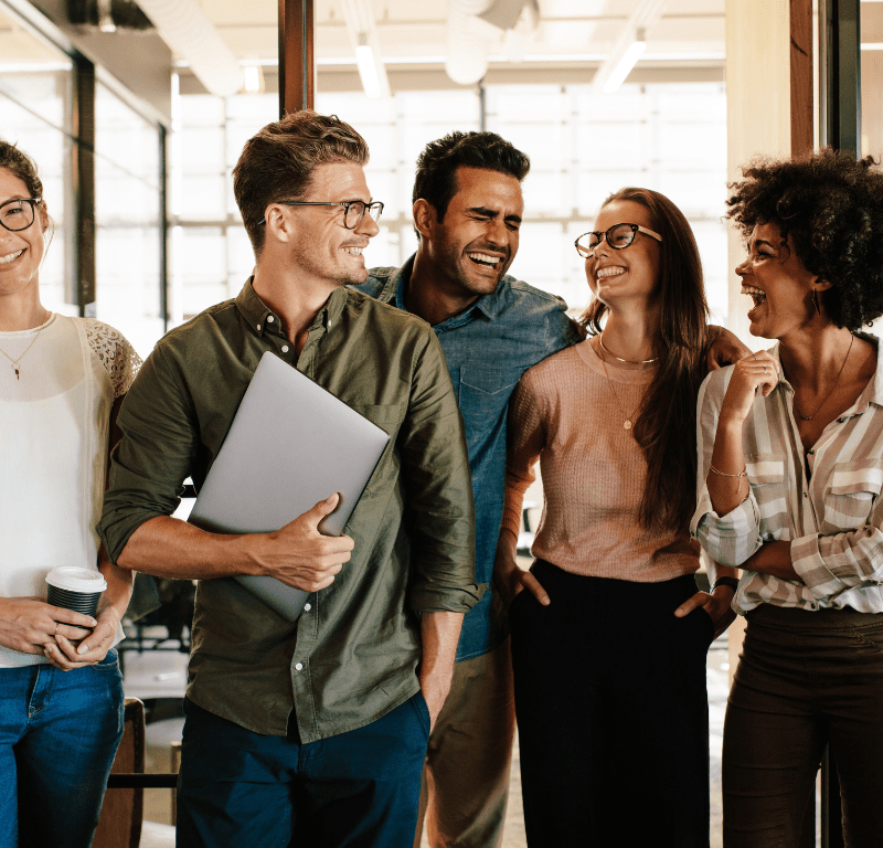 Header webinar soft skills en entreprise - Equipe dans le travail qui sourit avec ordinateur à la main